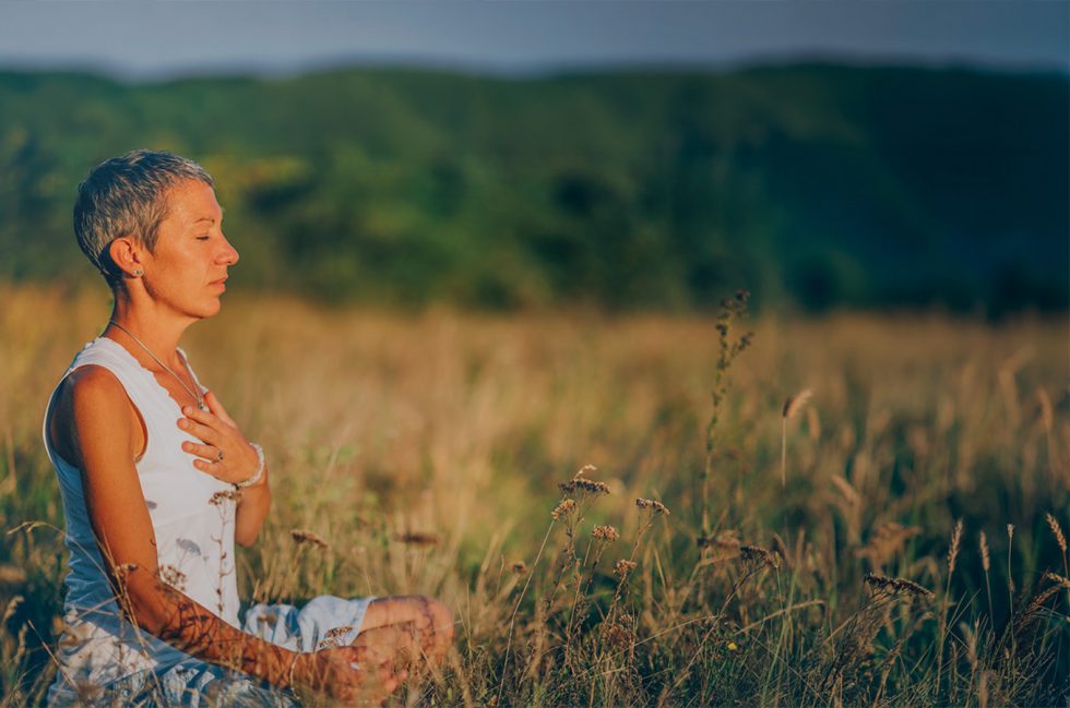 a woman mediates in a field